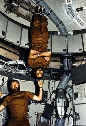  NASA     ВНУТРИ СТАНЦИИ командир экспедиции Дж.Карр указательным пальцем держит на весу пилота У.Поуга – наглядная иллюстрация невесомости в космосе. Фотоснимок сделан Э.Гибсоном. Три космонавта провели почти три месяца в 1973–1974 на борту космической станции «Скайлэб». Этого времени им вполне хватило, чтобы отрастить бороды.
