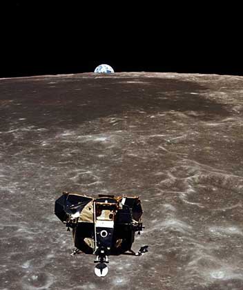  NASA     ВЗЛЕТНАЯ КАБИНА «ИГЛ» НАД ПОВЕРХНОСТЬЮ ЛУНЫ. Снимок сделан во время исторического полета «Аполлона-11» М.Коллинзом из отсека экипажа основного блока. Виден «восход» Земли над лунным горизонтом.