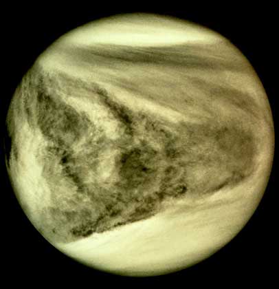  IGDA     ВЕНЕРА. Изображение в ультрафиолетовых лучах, полученное с борта межпланетной станции «Пионер-Венера», демонстрирует атмосферу планеты, плотно заполненную облаками, более светлыми в полярных областях (вверху и внизу снимка).