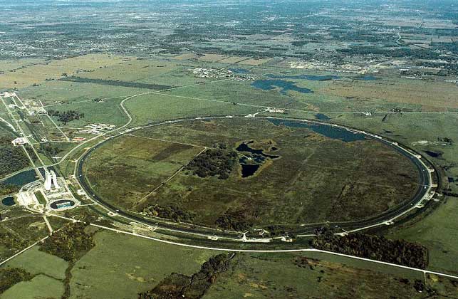  IGDA/Fermilab     ЛАБОРАТОРИЯ ИМ. Э. ФЕРМИ близ Батавии (США). Длина окружности «Главного кольца» ускорителя составляет 6,3 км. Кольцо расположено на глубине 9 м под окружностью в центре снимка.