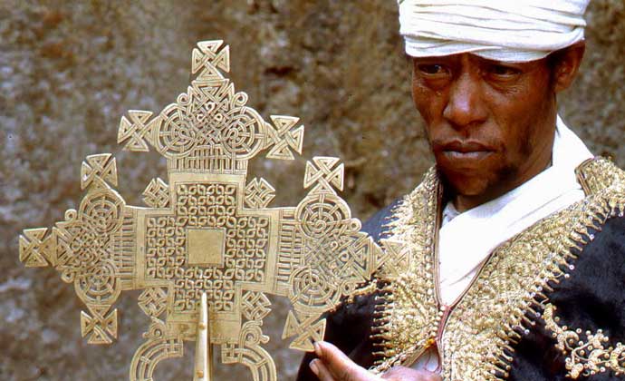 СВЯЩЕННОСЛУЖИТЕЛЬ стоит рядом с коптским крестом, символом Христианской Коптской церкви, которая была создана в 4 в. в Египте св. Антонием и имеет большое число приверженцев в Эфиопии. IGDA/A. Tessore