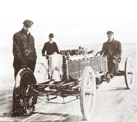 ГЕНРИ  ФОРД (сидит за рулевым колесом) и двое его коллег у специального шестицилиндрового гоночного автомобиля в Дейтоне-Бич (Флорида) в 1905.